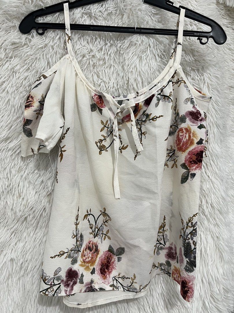 White Cold Shoulder Floral Tie Front Top (Category: Sleeveless) located in Imus. Submitted by nomsthriftshop (Listing ID 1464216028, Image 1). Description: - Cute white top with a lovely floral print. - Features stylish cold shoulder sleeves. - Trendy tie front detail. - Made from lightweight and flowy fabric. - Versatile for casual outings or dressing up. - Easily pairs with jeans or skirts..