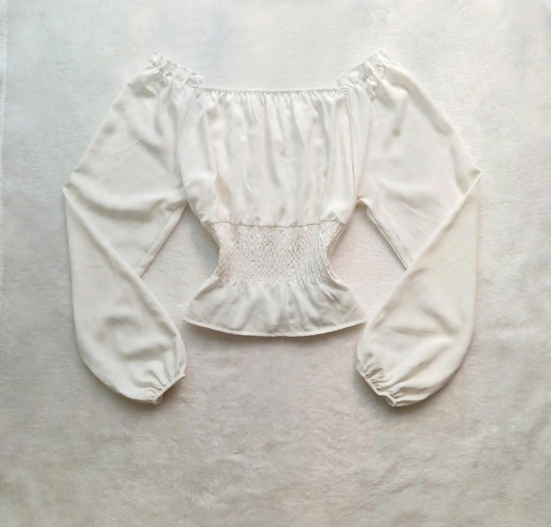 White Off-Shoulder Smocked Crop Top (Category: Blouses) located in Manila. Submitted by angelic.clot (Listing ID 1464239735, Image 2). Description: - White off-shoulder top - Long puff sleeves with elastic cuffs - Smocked bodice for a flattering fit - Versatile for casual or evening wear - Easy to pair with jeans or skirts.