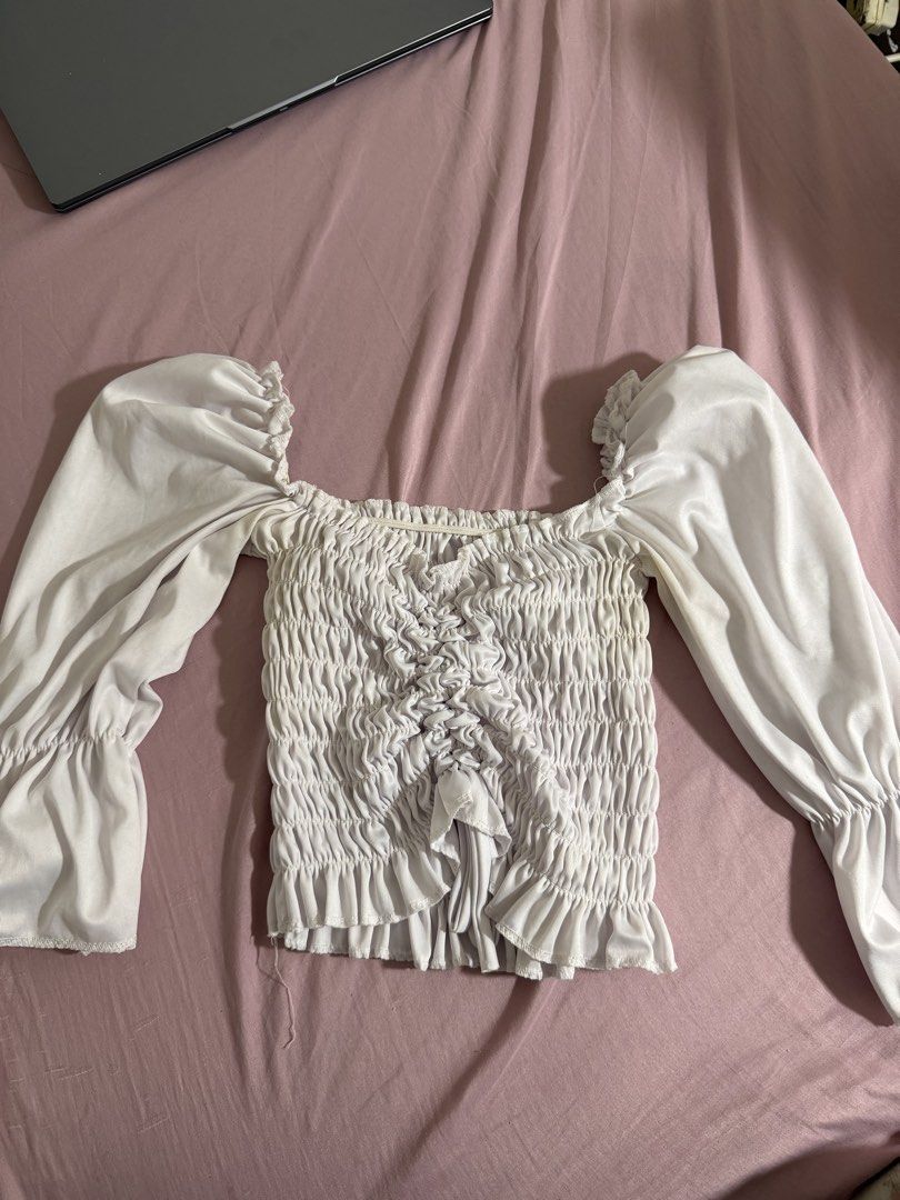 White Smocked Square Neck Puff Sleeve Top (Category: Blouses) located in San Fernando. Submitted by iammaryjoy58877 (Listing ID 1464153559, Image 1). Description: - Cute white top - Smocked front - Puff sleeves - Square neckline - Ruffled hem and cuffs - Versatile for night out or casual wear - Easy to pair with jeans or skirts.