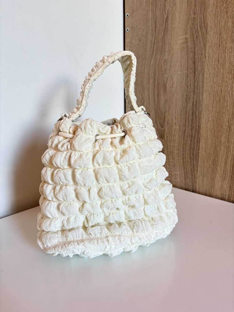 White Textured Bucket Bag with Drawstring Closure (Category: Shoulder Bags) located in Taal. Submitted by aliafrncsca (Listing ID 1464163578, Image 2). Description: - Adorable white bucket bag - Unique all-over textured material - Secure drawstring closure with a stylish metal accent - Textured handle for comfortable carrying - Ideal for everyday use, fits all your essentials.