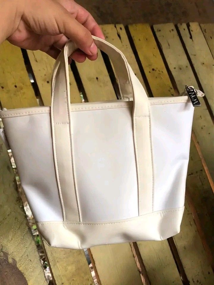White Tote Bag with Logo Tag (Category: Tote Bags) located in Manila. Submitted by crischellascona (Listing ID 1464276038, Image 1). Description: Cute white tote bag, perfect for everyday or travel. Features two handles, a contrasting base, and an easy-to-clean material. Includes a small logo tag on the zipper..