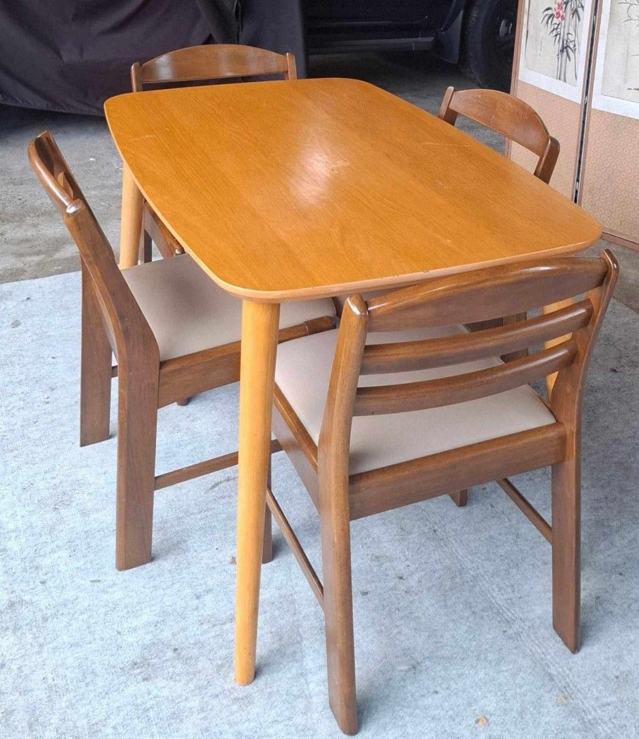 Wooden Dining Table and 4 Chairs Set (Category: Tables & Sets) located in Antipolo. Submitted by roselle001 (Listing ID 1464218654, Image 1). Description: - Light wood dining table with a smooth, rounded corner design. - Comes with 4 matching chairs in a darker wood finish. - Chairs feature comfortable light beige cushioned seats. - Elegant slatted back design on the chairs. - Angled table legs for a modern aesthetic. - Perfect for compact dining