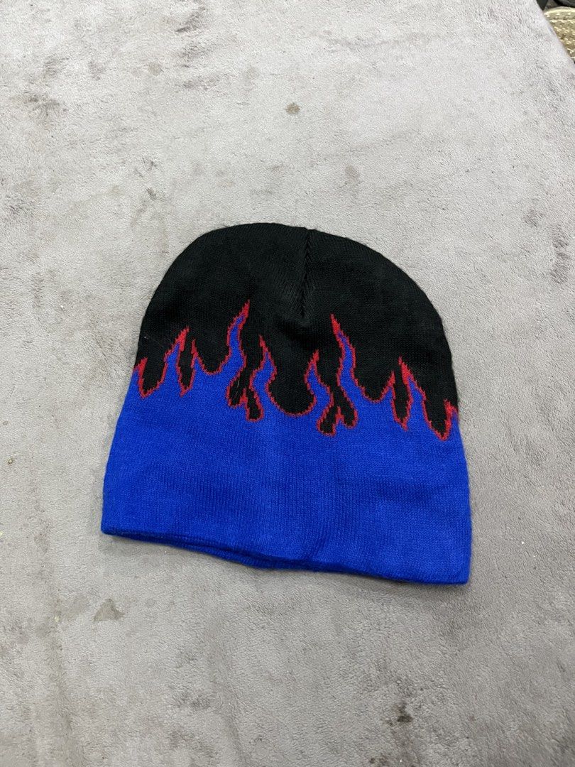 y2k-style flame knit beanie (Category: Beanies) located in General Trias. Submitted by zrchustle.604 (Listing ID 1464195242, Image 1). Description: y2k-style flame knit beanie, featuring a black crown with vibrant blue flames outlined in red. This classic design is highly popular in streetwear and vintage skate fashion..
