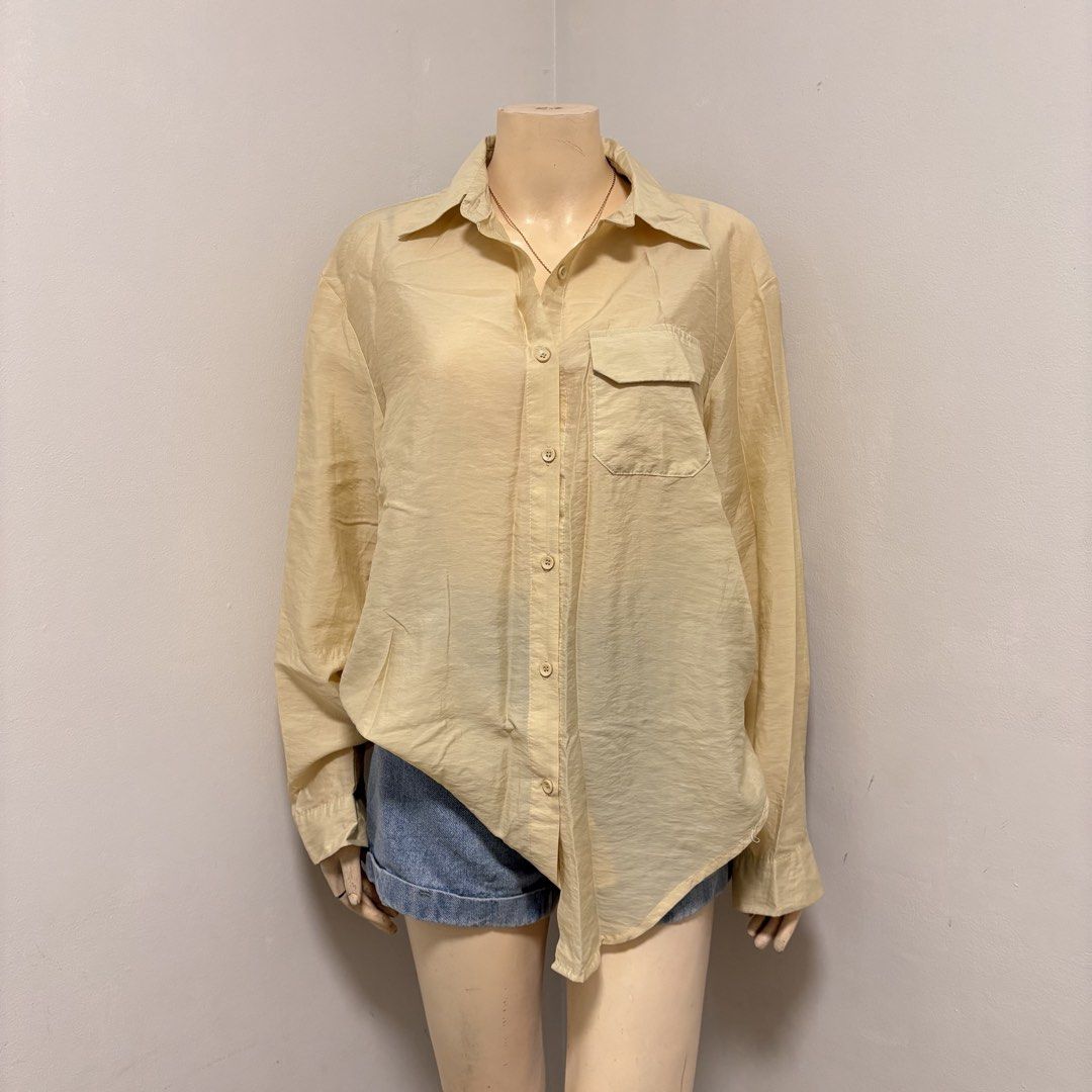 Yellow Buttondown Polo Longsleeves (Category: Longsleeves) located in Imus. Submitted by reloved.nd (Listing ID 1464261058, Image 1). Description: - Lightweight beige button-up shirt - Single chest pocket - Relaxed, oversized fit - Subtle crinkled fabric texture - Versatile styling: tuck into shorts or wear open over a tank top.