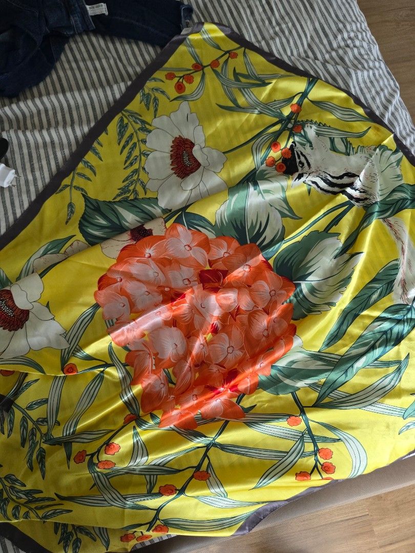 Yellow Printed Nature Silk Scarf (Category: Scarves) located in Paranaque City. Submitted by incognitopawikan (Listing ID 1464169494, Image 2). Description: - Beautiful yellow silk scarf - Vibrant floral print with orange and white flowers - Adorable animal (fox/badger) peeking through leaves - Dark trim along the edges - Versatile accessory to elevate any look.