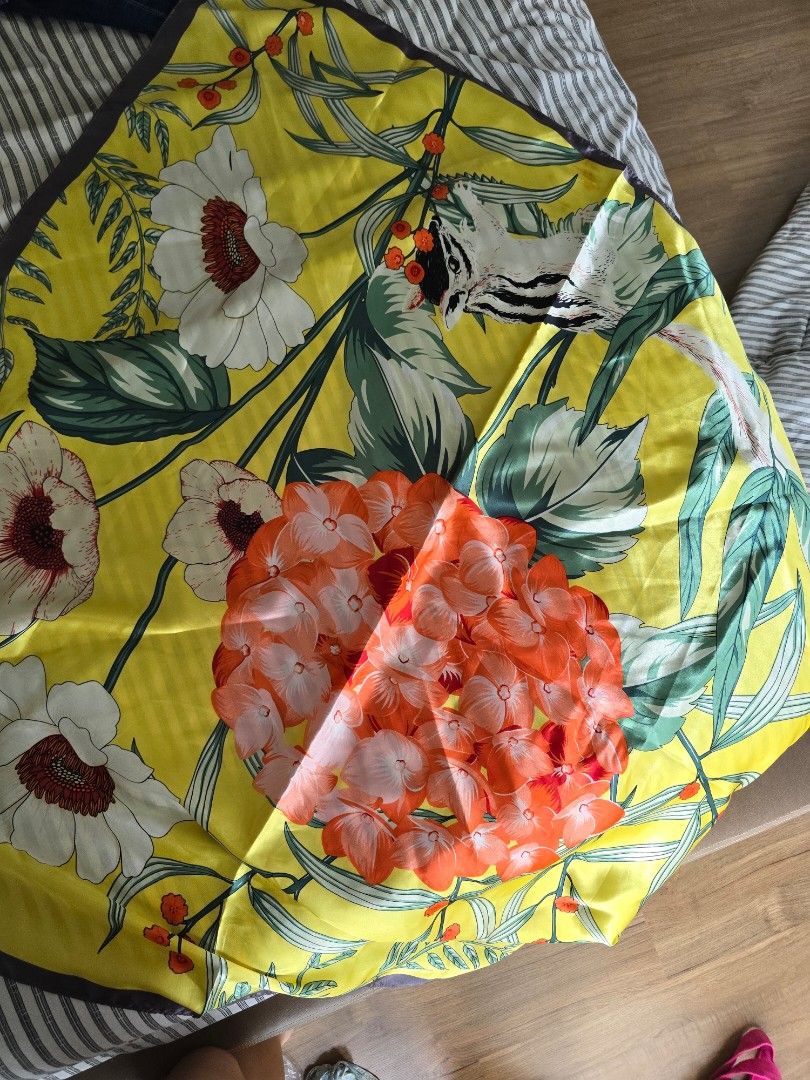 Yellow Printed Nature Silk Scarf (Category: Scarves) located in Paranaque City. Submitted by incognitopawikan (Listing ID 1464169494, Image 3). Description: - Beautiful yellow silk scarf - Vibrant floral print with orange and white flowers - Adorable animal (fox/badger) peeking through leaves - Dark trim along the edges - Versatile accessory to elevate any look.