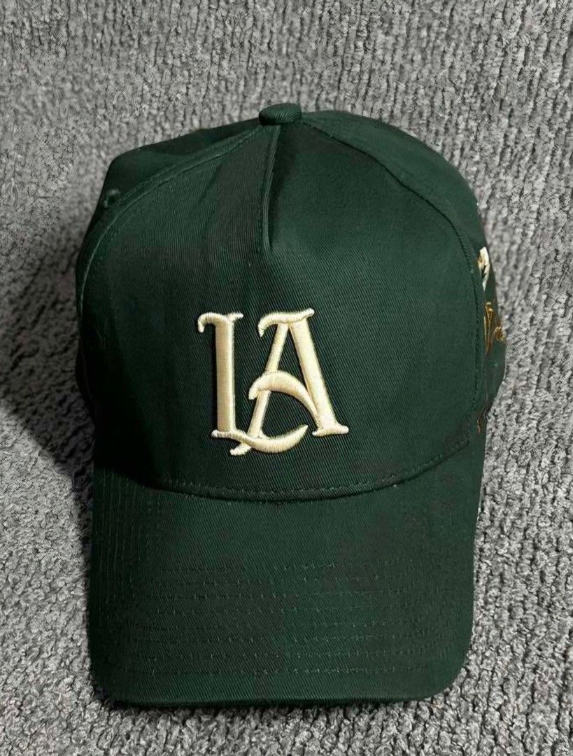 YOUNGLA Cap with Floral Embroidery (Category: Caps & Hats) located in La Trinidad. Submitted by odin21 (Listing ID 1464222079, Image 1). Description: - Color: Cool Green - Front Embroidery: 'LA' - Side Design: Floral with blue accents - Back Embroidery: 'YOUNGLA' - Condition: Shows some signs of wear, still looks good - Style: Great for casual wear.
