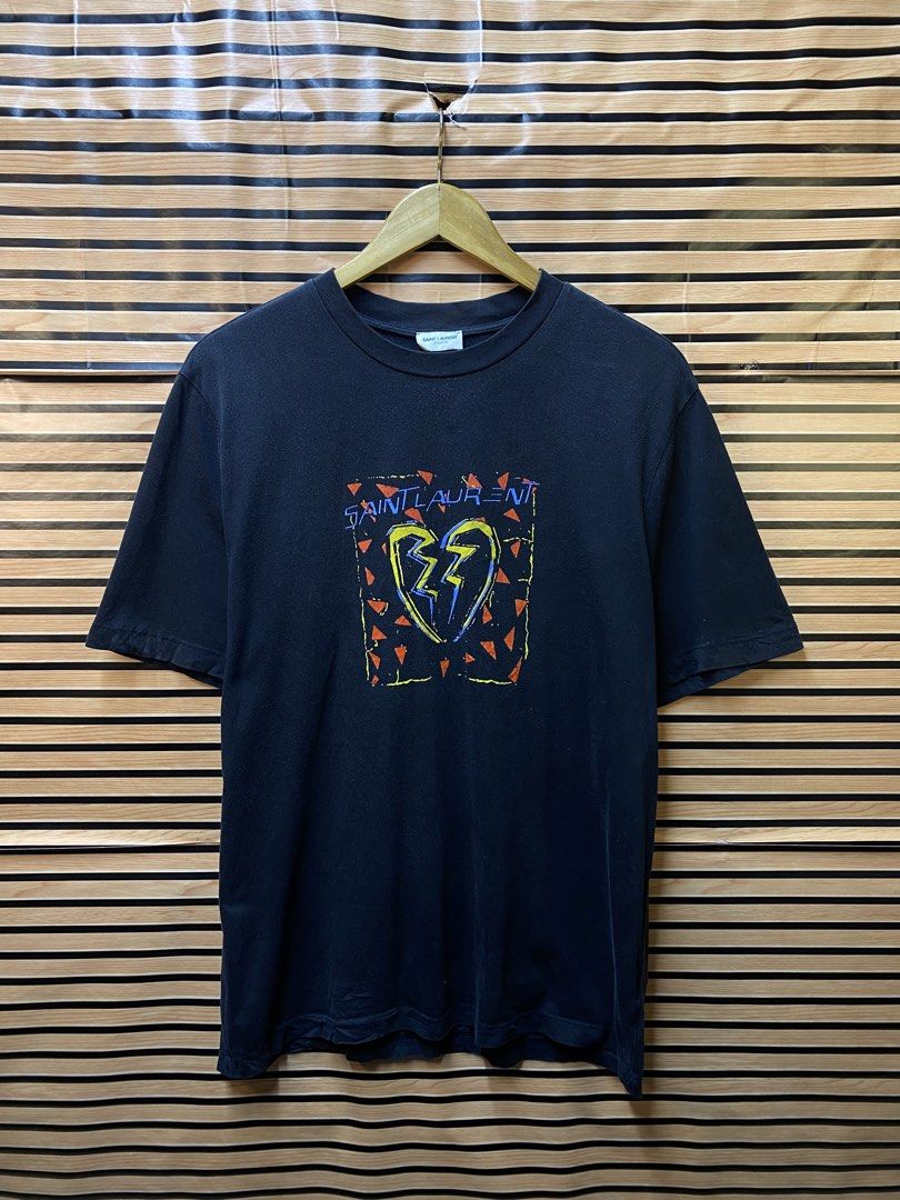 YSL “Broken Heart Jaguard” Tee (Category: Tshirts & Polo Shirts ) located in Makati City. Submitted by drip.poww (Listing ID 1464235857, Image 1). Description: - Authentic YSL - Color: Black - Size: Large - Dimes: 23x28 - Authentic - Excellent condition - Need wash, fresh from bale - Material: 100% Cotton Please don’t expect too much—these are thrifted (ukay) items. 😊 !!STILL NEGOTIABLE!!.
