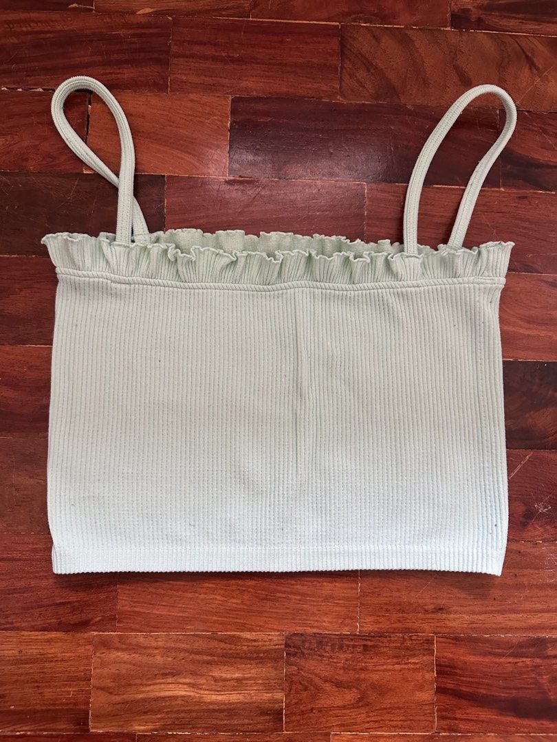 Zara Ribbed Ruffle Strap Crop Top (Category: Sleeveless) located in Cainta. Submitted by buy.preloved (Listing ID 1464218862, Image 1). Description: - Light green ribbed crop top from Zara - Features a cute ruffled trim along the neckline - Delicate spaghetti straps - Stretchy material for a comfortable fit - Versatile for layering or wearing solo.
