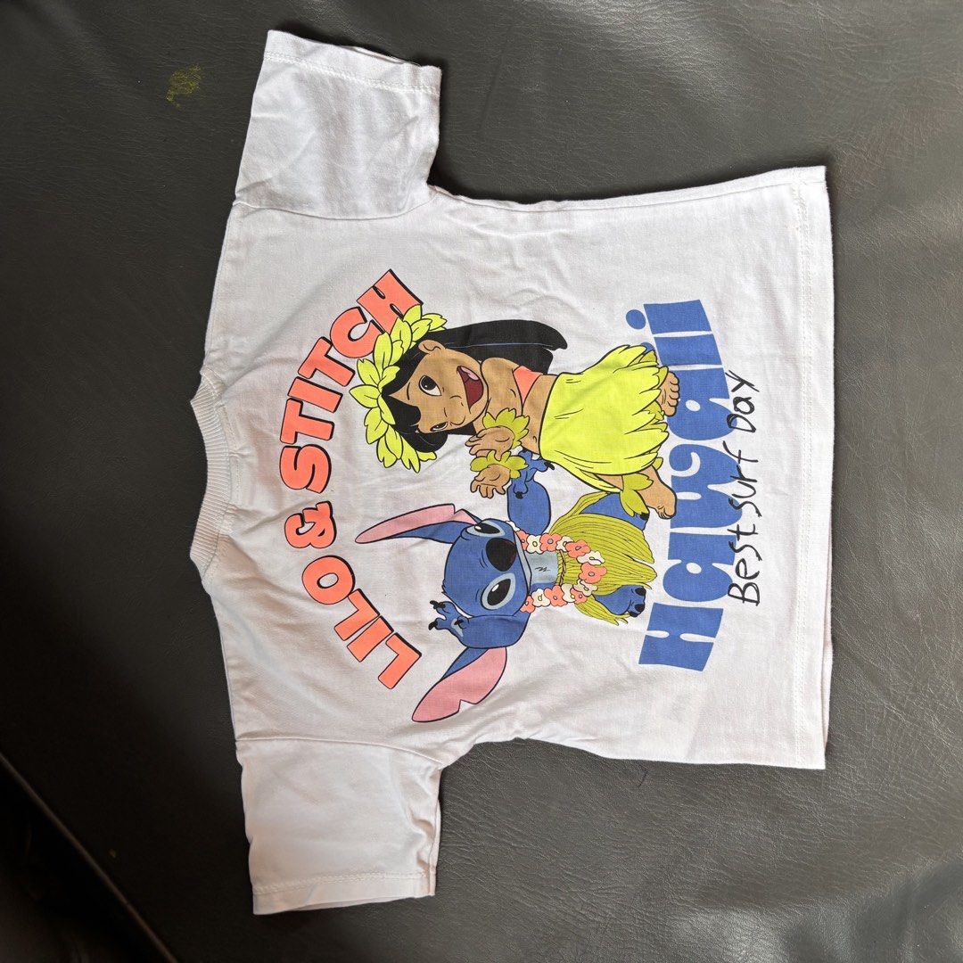 ZARA Stitch T-shirt (2 Years) (Category: Babies & Kids Fashion) located in Mati. Submitted by sharieeng (Listing ID 1464145737, Image 2). Description: - Soft cotton white t-shirt - Features Stitch and Lilo graphics - Front design: 'Stitch Best Surf Day' - Back design: 'Lilo & Stitch Hawaii Best Surf Day' - Ideal for fans of Lilo & Stitch.
