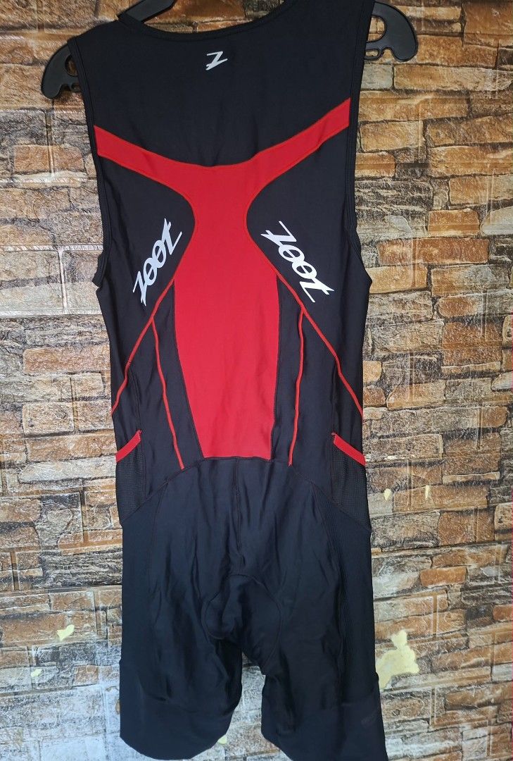 Zoot Men Triathlon Suit (Category: Water Sports) located in Manila. Submitted by paulzip73 (Listing ID 1464182126, Image 2). Description: 🏷️ Zoot Sleeveless Tri Suit — Red & Black Brand: Zoot — premium triathlon & endurance sport apparel Type: Men's one-piece sleeveless triathlon suit (swim → bike → run) Color: Red main body with black side panels, red contrast stitching Material: High-performance moisture-wicking quick-dry Italian fabric — brea