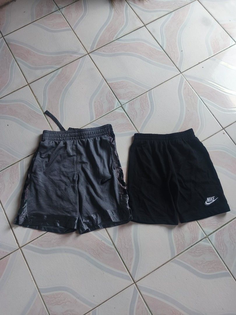 2 Pairs Nike Shorts - Black & Grey (Category: Babies & Kids Fashion) located in Manila. Submitted by cookthrift (Listing ID 1464371921, Image 1). Description: - Two pairs of Nike shorts available: one black, one grey. - Both feature comfortable elastic waistbands with adjustable drawstrings. - The grey pair includes a stylish mesh outer layer. - Versatile for sports activities or everyday casual wear. - Special offer: Get both pairs together for 