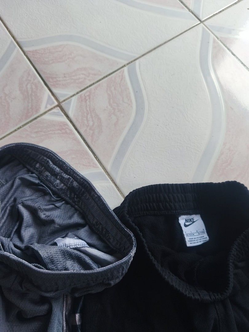 2 Pairs Nike Shorts - Black & Grey (Category: Babies & Kids Fashion) located in Manila. Submitted by cookthrift (Listing ID 1464371921, Image 2). Description: - Two pairs of Nike shorts available: one black, one grey. - Both feature comfortable elastic waistbands with adjustable drawstrings. - The grey pair includes a stylish mesh outer layer. - Versatile for sports activities or everyday casual wear. - Special offer: Get both pairs together for 