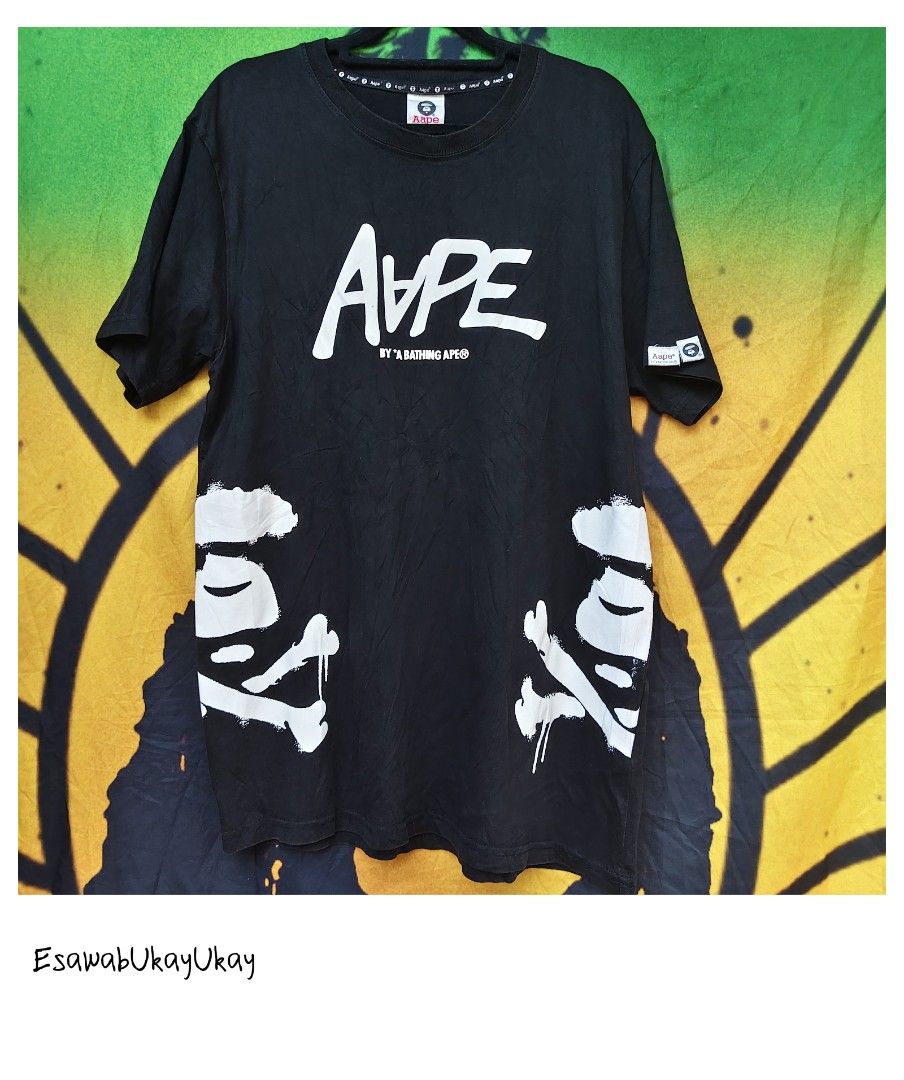 AAPE shirt (Category: Activewear) located in Lucena. Submitted by esawabthriftshopatbp (Listing ID 1464391352, Image 1). Description: This black AAPE by A Bathing Ape tee features a bold white brush-stroke logo across the chest paired with distinctive distressed crossbone graphics near the hem..