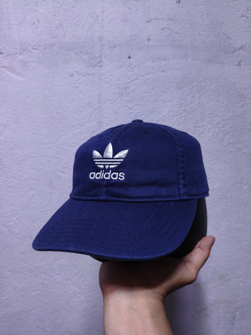 Adidas Cap Blue Trefoil Logo Cap (Category: Caps & Hats) located in Malilipot. Submitted by aronbigorn96320 (Listing ID 1464489509, Image 1). Description: - Classic Adidas cap in a nice blue color. - Features the iconic trefoil logo embroidered on the front. - Adjustable strap at the back for a comfortable fit. - Made from 100% cotton. - Great for everyday wear. - Womens or youth size.