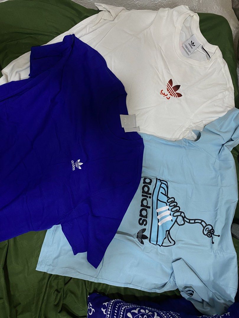 Adidas T-Shirts Bundle (White, Blue, Light Blue) (Category: Tshirts & Polo Shirts ) located in Manila. Submitted by cyyruss (Listing ID 1464374418, Image 1). Description: - 500 each - Set of 3 Adidas T-shirts (₱1700 - sure buyer) - Colors: White (small red logo), Royal Blue (small white logo), Light Blue (fun shoe & worm graphic) - Condition: All in good shape - Perfect for casual everyday wear.