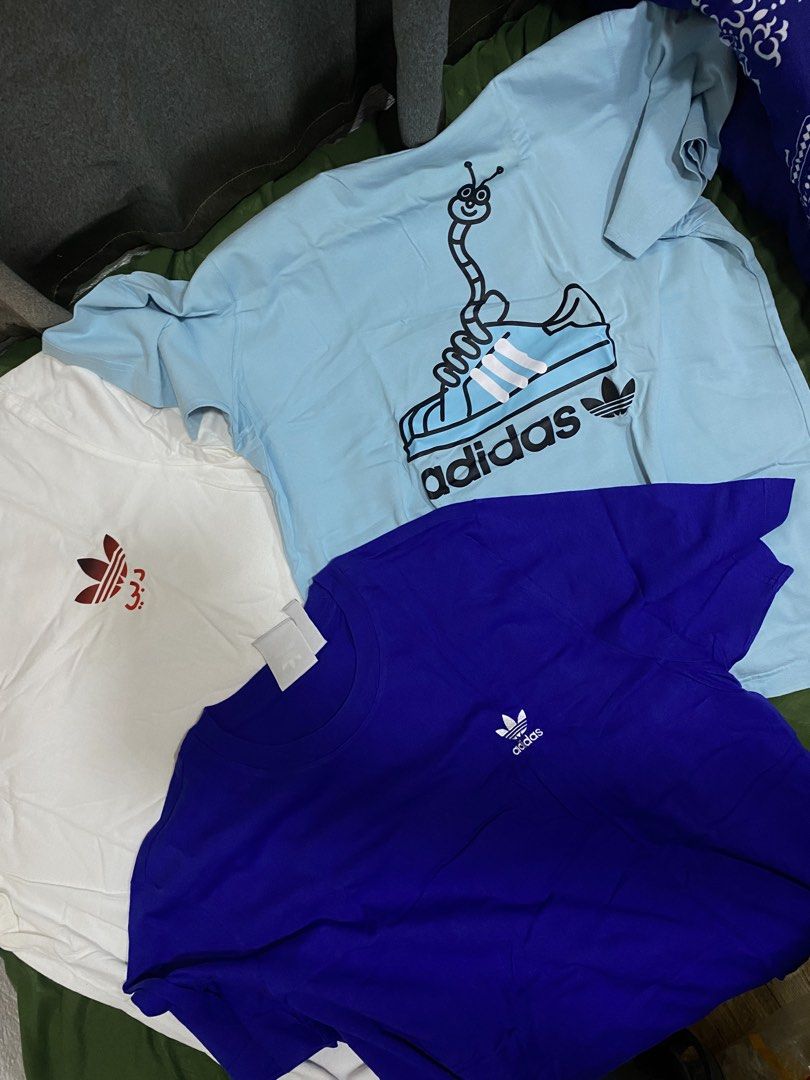 Adidas T-Shirts Bundle (White, Blue, Light Blue) (Category: Tshirts & Polo Shirts ) located in Manila. Submitted by cyyruss (Listing ID 1464374418, Image 3). Description: - 500 each - Set of 3 Adidas T-shirts (₱1700 - sure buyer) - Colors: White (small red logo), Royal Blue (small white logo), Light Blue (fun shoe & worm graphic) - Condition: All in good shape - Perfect for casual everyday wear.