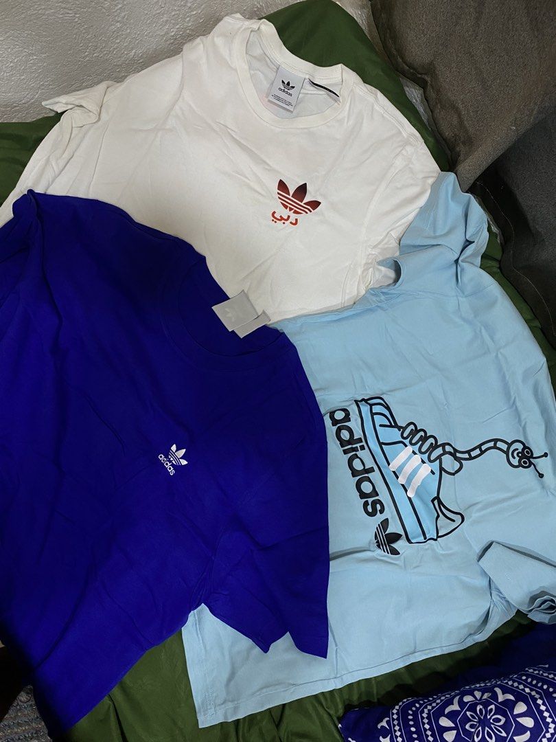 Adidas T-Shirts Bundle (White, Blue, Light Blue) (Category: Tshirts & Polo Shirts ) located in Manila. Submitted by cyyruss (Listing ID 1464374418, Image 2). Description: - 500 each - Set of 3 Adidas T-shirts (₱1700 - sure buyer) - Colors: White (small red logo), Royal Blue (small white logo), Light Blue (fun shoe & worm graphic) - Condition: All in good shape - Perfect for casual everyday wear.