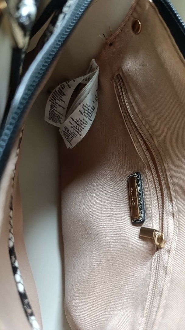 ALDO Cream & Brown Top Handle Bag (Category: Luxury Bags & Wallets) located in Manila. Submitted by clm01 (Listing ID 1464430485, Image 2). Description: - Elegant cream handbag with sophisticated brown trim and strap. - Luxurious snake print interior lining for a touch of flair. - Secure main zippered compartment to keep your essentials safe. - Convenient internal zip pocket for smaller items. - Stylish gold hardware details add a premium finish.