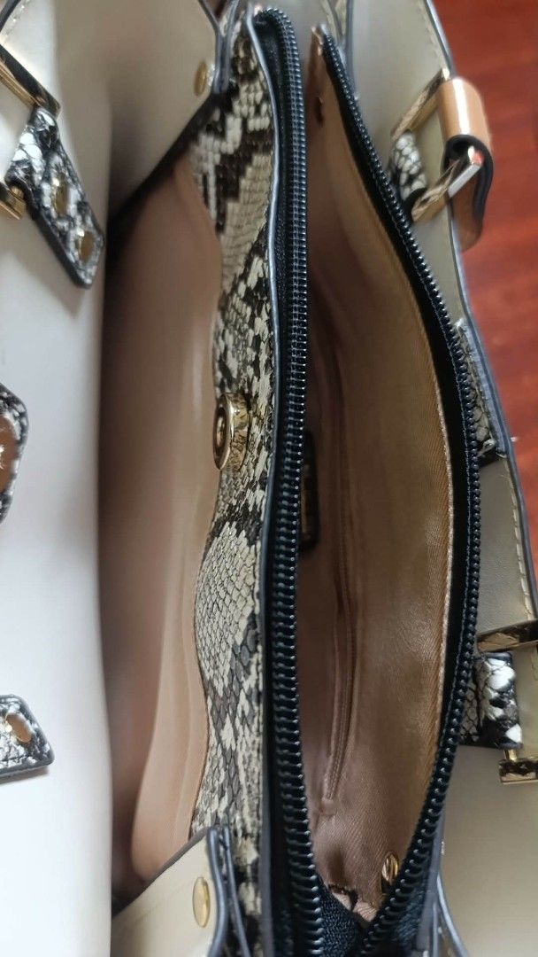 ALDO Cream & Brown Top Handle Bag (Category: Luxury Bags & Wallets) located in Manila. Submitted by clm01 (Listing ID 1464430485, Image 3). Description: - Elegant cream handbag with sophisticated brown trim and strap. - Luxurious snake print interior lining for a touch of flair. - Secure main zippered compartment to keep your essentials safe. - Convenient internal zip pocket for smaller items. - Stylish gold hardware details add a premium finish.