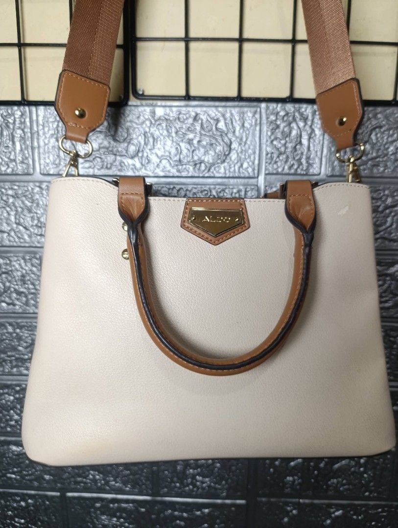 ALDO Cream & Brown Top Handle Bag (Category: Luxury Bags & Wallets) located in Manila. Submitted by clm01 (Listing ID 1464430485, Image 1). Description: - Elegant cream handbag with sophisticated brown trim and strap. - Luxurious snake print interior lining for a touch of flair. - Secure main zippered compartment to keep your essentials safe. - Convenient internal zip pocket for smaller items. - Stylish gold hardware details add a premium finish.