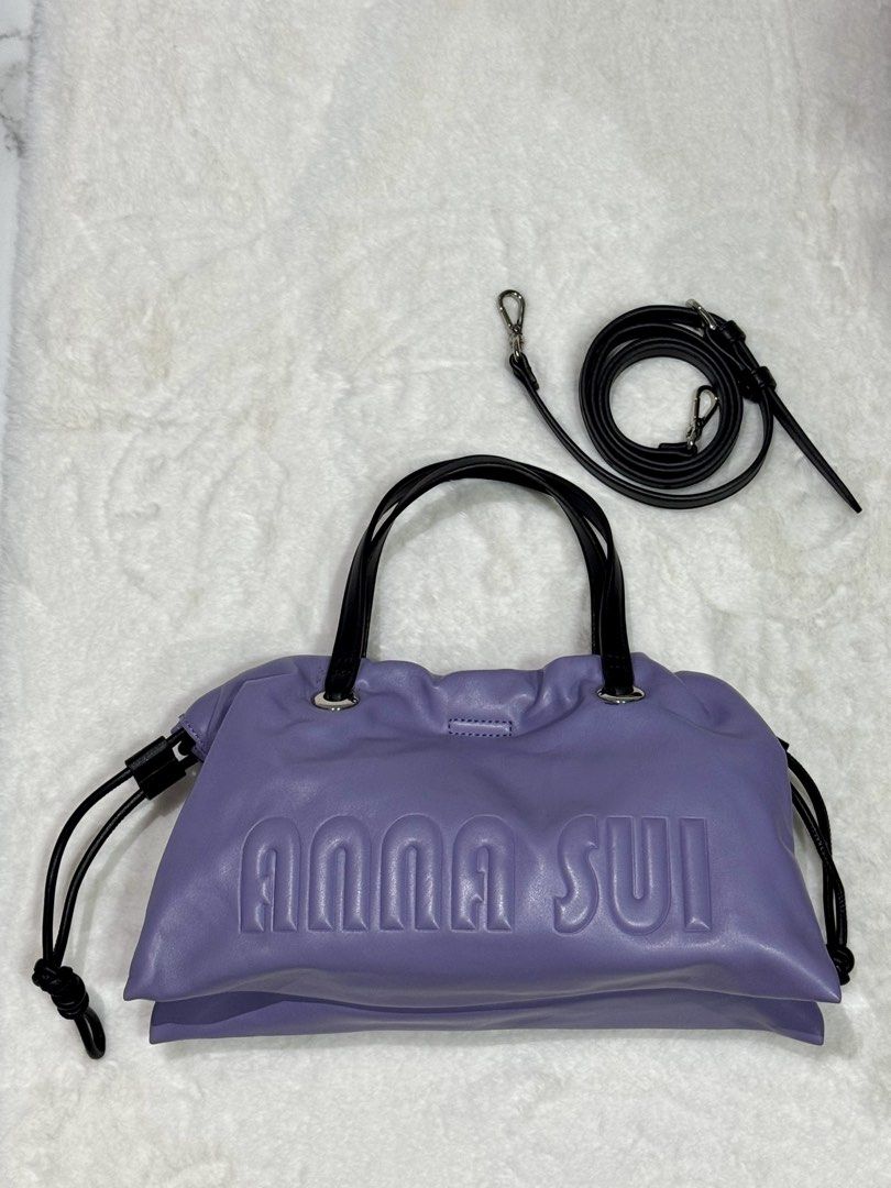 ANNA SUI Purple Leather Drawstring Handbag with Shoulder Strap (Category: Shoulder Bags) located in San Nicolas. Submitted by ihascat (Listing ID 1464449925, Image 1). Description: - Authentic ANNA SUI purple leather handbag - Drawstring closure - Black handles - Detachable black shoulder strap included - Great everyday size.
