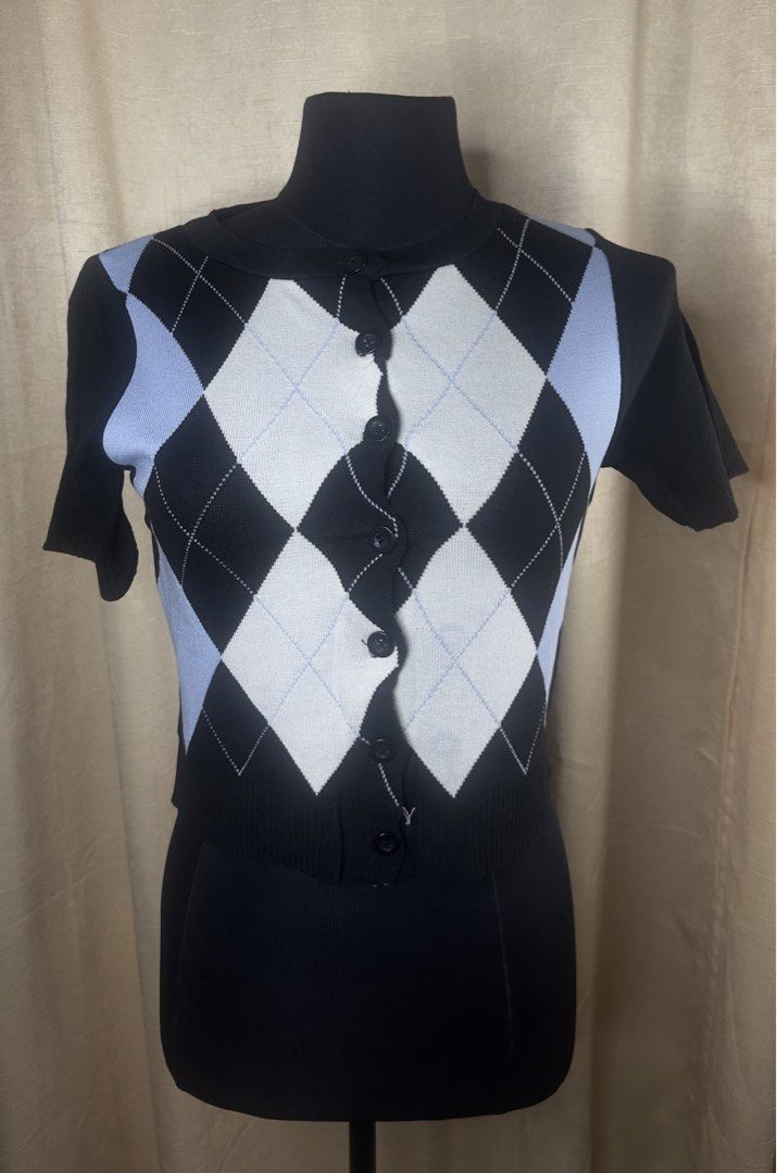 Argyle Knit Short Sleeve Button Up Top (Category: Blouses) located in Cainta. Submitted by vestito_bestida (Listing ID 1464462223, Image 2). Description: ⛔️ACTUAL PHOTO POSTED⛔️ 👉 Brandnew 👉 BKK Argyle Knitted Short Sleeve Top 👉 Size: free size 🌸 Cute argyle knit top 🌸 Short sleeves 🌸 Black with white and light blue diamond pattern 🌸 Free size fits most 🌸 Versatile for casual or dressed-up styling 🌸 Perfect for everyday wear 👉 Flatlay m