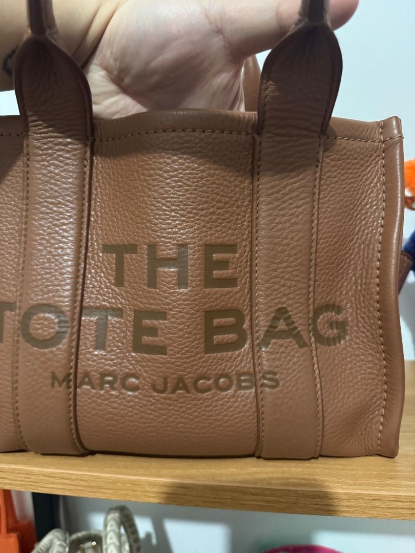 AUTHENTIC Marc Jacobs The Tote Bag Mini / Small - Argan Oil (Category: Tote Bags) located in Quezon City. Submitted by afpar (Listing ID 1464495010, Image 2). Description: - Purchased from Farfetch - Some signs of usage on the corners, but not too obvious - Comes with a free guitar strap in Argan Oil too.
