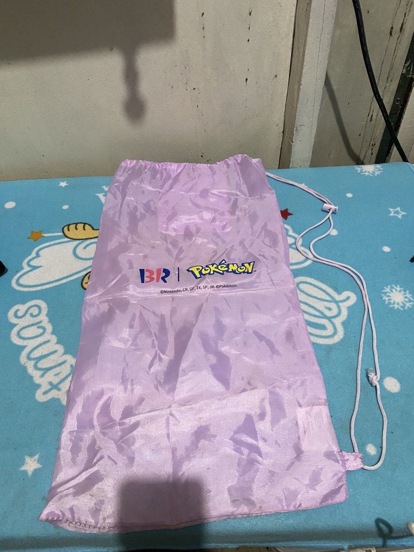 Baskin Robbins x Pokemon Promotional Drawstring Bag (Category: Backpacks) located in Manila. Submitted by resi.diaz (Listing ID 1464511015, Image 2). Description: - Light purple drawstring bag - Bag only. NO badminton rackets inside. - Features Baskin Robbins and Pokemon logos - Includes a small inner pocket - Ideal for carrying small items - Makes a great gift for Pokemon fans - Easy drawstring closure.