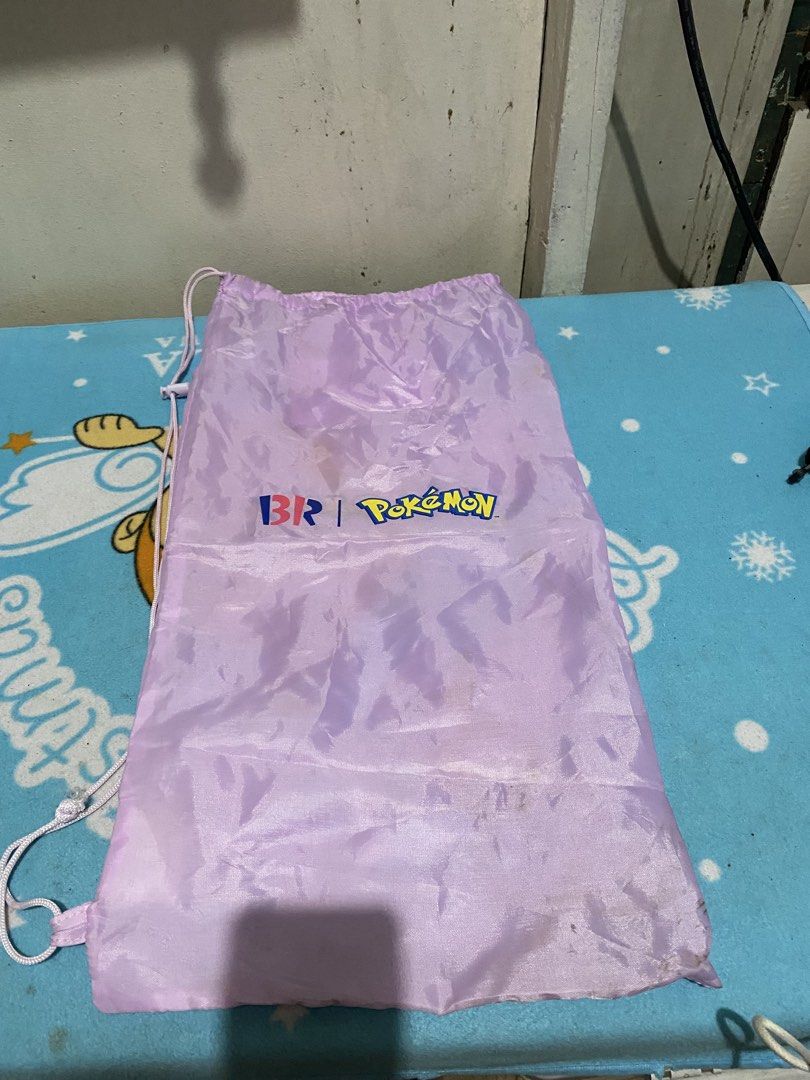 Baskin Robbins x Pokemon Promotional Drawstring Bag (Category: Backpacks) located in Manila. Submitted by resi.diaz (Listing ID 1464511015, Image 1). Description: - Light purple drawstring bag - Bag only. NO badminton rackets inside. - Features Baskin Robbins and Pokemon logos - Includes a small inner pocket - Ideal for carrying small items - Makes a great gift for Pokemon fans - Easy drawstring closure.