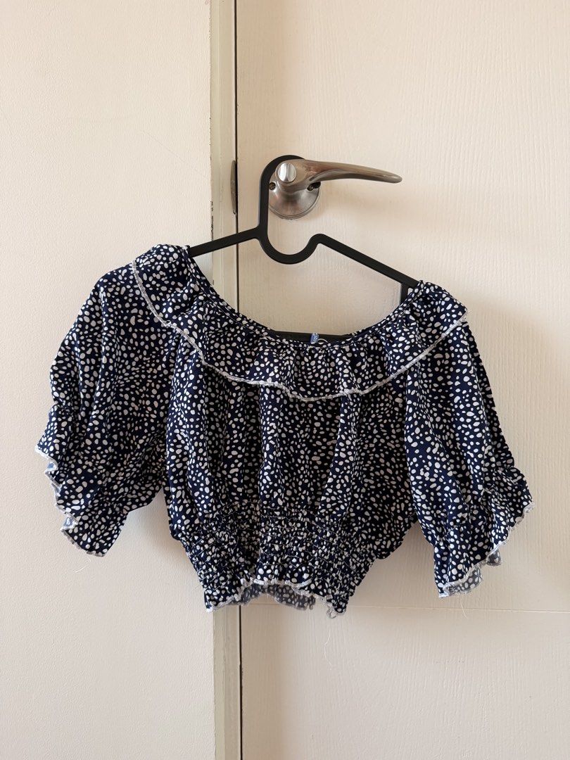 BEA&CQS Navy and White Off Shoulder Crop Top (Category: Blouses) located in Manila. Submitted by pvreal (Listing ID 1464443096, Image 2). Description: - Brand: BEACO&COS - Style: Off-shoulder crop top - Color: Navy blue with white spots print - Features: Ruffled neckline, elasticated hem, short puff sleeves with ruffled cuffs - Occasion: Casual day out, beach trip - Styling: Easy to pair with shorts or jeans.