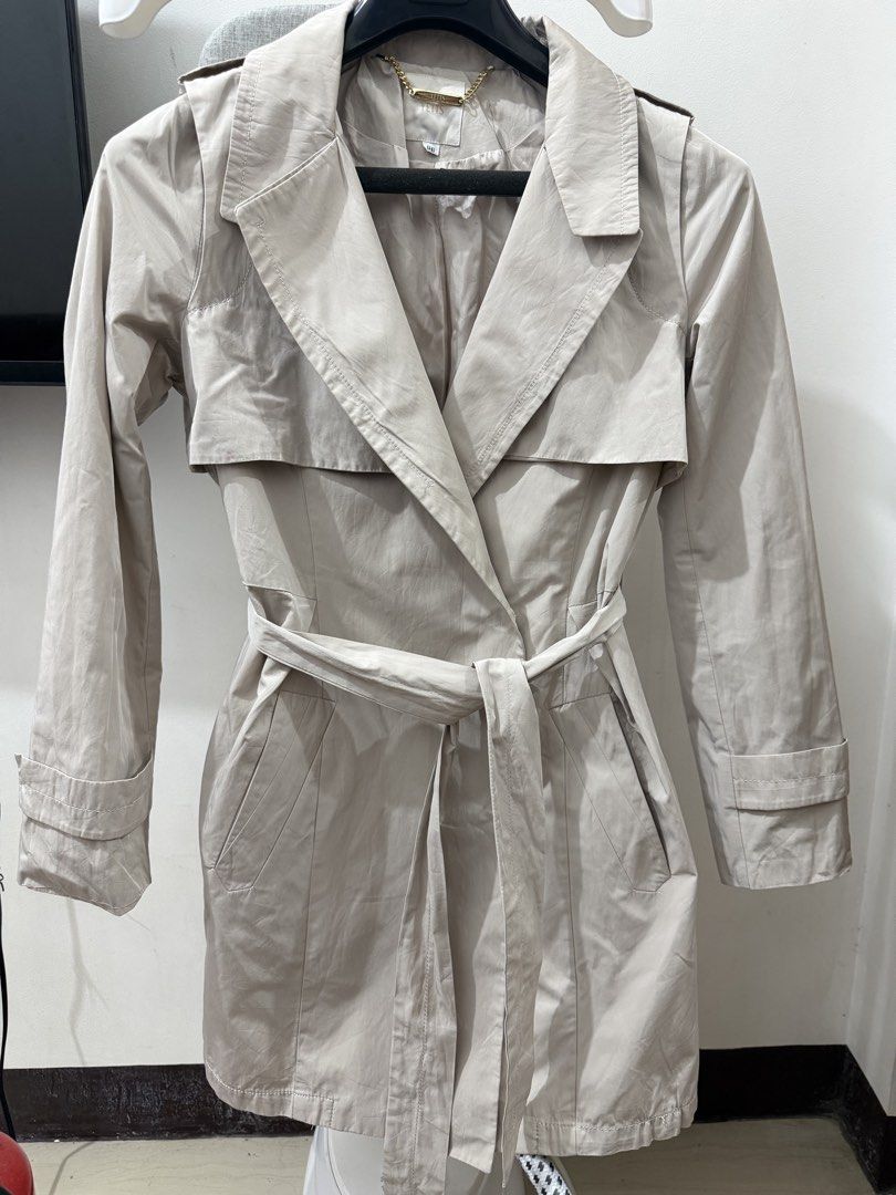 Beige Double-Breasted Belted Trench Coat (Category: Coats, Jackets and Outerwear) located in Makati City. Submitted by petite_preloved2 (Listing ID 1464357096, Image 1). Description: - Classic beige trench coat - Includes matching belt - Functional pockets - Back vent for ease of movement - Smooth, silky interior I’m 5ft, semi medium built.