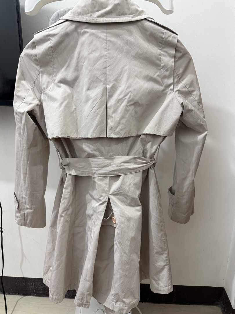 Beige Double-Breasted Belted Trench Coat (Category: Coats, Jackets and Outerwear) located in Makati City. Submitted by petite_preloved2 (Listing ID 1464357096, Image 2). Description: - Classic beige trench coat - Includes matching belt - Functional pockets - Back vent for ease of movement - Smooth, silky interior I’m 5ft, semi medium built.