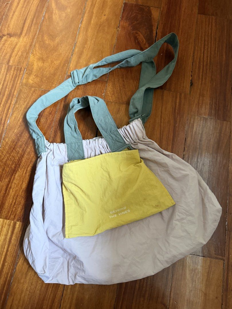 Beyond The Vines DUMPLING Tri color XL (Category: Tote Bags) located in Manila. Submitted by sgdk0115 (Listing ID 1464565114, Image 1). Description: - Brand: Beyond The Vines - Color: Light purple main bag, bright yellow front pocket - Features: Gathered top, green straps, front pocket with brand name - Material: Lightweight - Versatile: Can be worn as a shoulder bag or tote - Ideal for: Everyday use RFS: decluttering Flaws: little dirt in the po