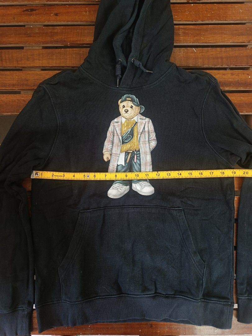 Black Hoodie with Bear Graphic (Category: Coats, Jackets and Outerwear) located in Calamba. Submitted by sulitshopaholic (Listing ID 1464357302, Image 2). Description: - Stylish black hoodie featuring a cool bear graphic on the front. - Equipped with a convenient front pocket for your essentials. - Adjustable hood with drawstrings for a customized fit. - Approximate measurements: 18 inches (pit to pit) and 25 inches (length). - Ideal for casual o