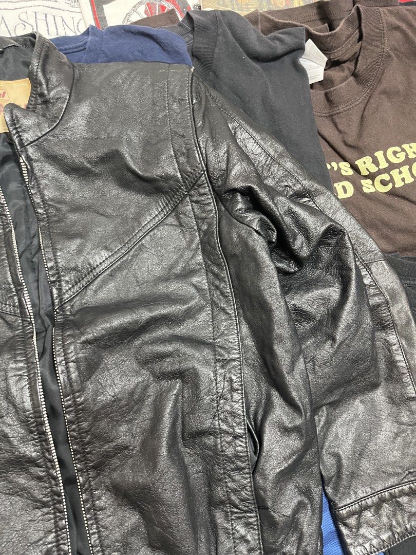 Black Leather Bomber Jacket (Category: Coats, Jackets and Outerwear) located in Baao. Submitted by plainclothesdept (Listing ID 1464533311, Image 2). Description: Jha Jha Leather Jacket width - 17 in. length - 22 in. no flaws - Classic black leather bomber jacket - Zip-up front - Elasticated cuffs and hem - Two front pockets - Estimated size: Medium - Perfect for layering or wearing on its own - A wardrobe essential.