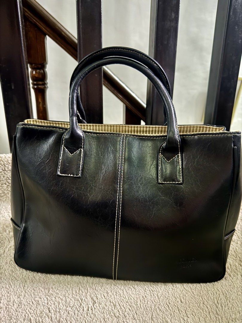 Black Leather Tote Handbag (Category: Tote Bags) located in Manila. Submitted by johfrancisco (Listing ID 1464422445, Image 1). Description: - Classic black tote bag - Made of durable faux leather - Interior features a stylish striped fabric lining - Elegant stitching details on the front - Comfortable top handles for easy carrying - Ample space for all your essentials - Perfect for work, school, or everyday use.