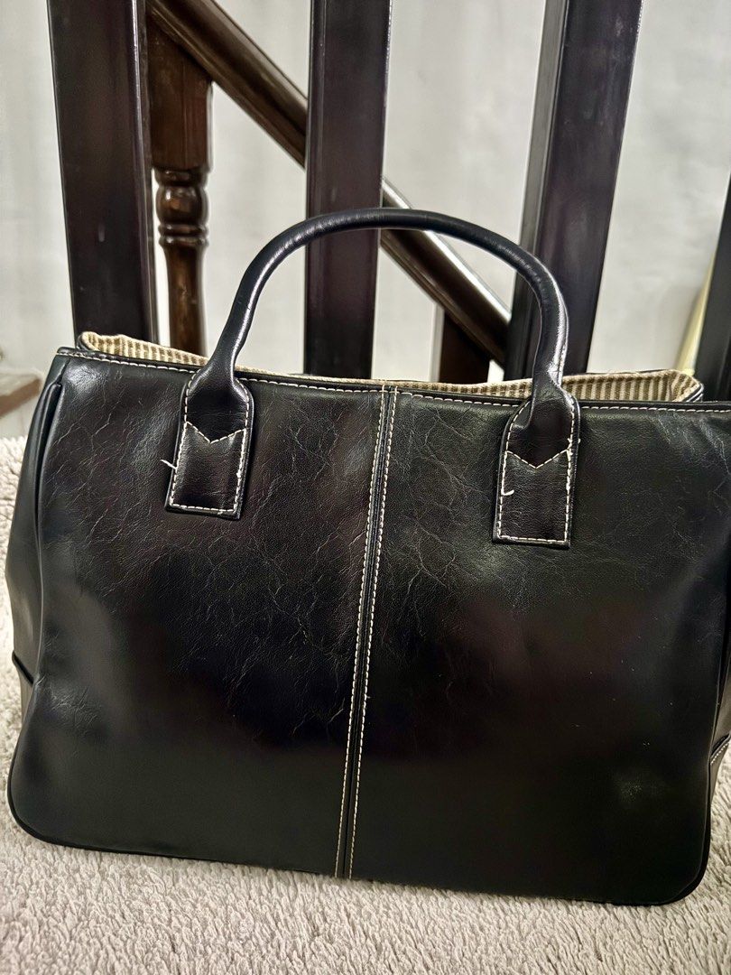 Black Leather Tote Handbag (Category: Tote Bags) located in Manila. Submitted by johfrancisco (Listing ID 1464422445, Image 2). Description: - Classic black tote bag - Made of durable faux leather - Interior features a stylish striped fabric lining - Elegant stitching details on the front - Comfortable top handles for easy carrying - Ample space for all your essentials - Perfect for work, school, or everyday use.