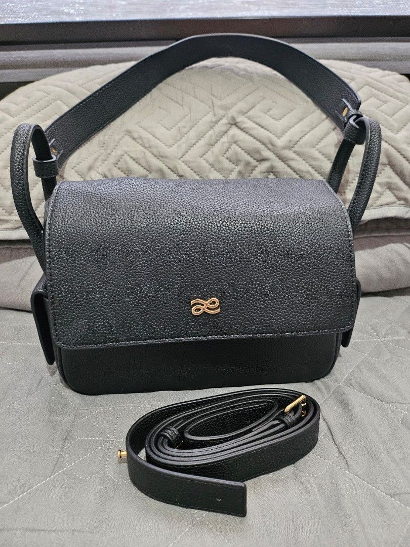 Black Textured Leather Handbag with Gold Logo (Category: Luxury Bags & Wallets) located in Manila. Submitted by maggiesilang (Listing ID 1464456001, Image 1). Description: - Chic black textured leather handbag - Elegant gold logo accent on the front - Versatile with two strap options: short handle and long adjustable strap - Immaculate and clean interior - Ideal for both daily errands and special events.