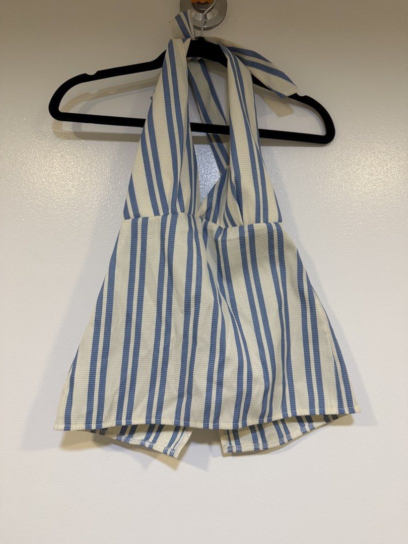 Blue and White Striped Halter Top (Category: Sleeveless) located in Mandaluyong City. Submitted by closet.me (Listing ID 1464479992, Image 1). Description: - Cute blue and white striped halter top - Ties at the neck - Slightly flared hem - Versatile: pairs well with shorts or jeans - Ideal for casual outings or beach trips.