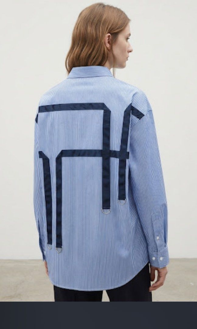 Blue Striped Oversized Shirt with Back Detail (Category: Shirts) located in Donsol. Submitted by saksthriftavenuebyluckymaria8 (Listing ID 1464488449, Image 3). Description: - Oversized blue and white striped button-up shirt - Long sleeves with button cuffs - Relaxed fit for comfort and style - Unique navy ribbon detail with D-rings on the back - Perfect for casual or dressed-up outfits - Pairs well with jeans or trousers Chest 25in length 28in a