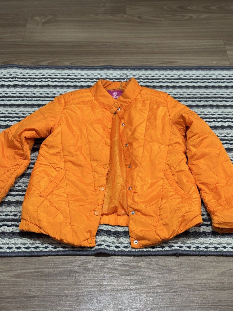 (BRAND NEW) Orange Quilted Puffer Jacket (Category: Coats, Jackets and Outerwear) located in Makati City. Submitted by siopao014 (Listing ID 1464419185, Image 3). Description: - Bright orange quilted puffer jacket - Stand-up collar with button closure - Snap button front - Two side pockets - Ideal for cooler weather - Warm and stylish design.