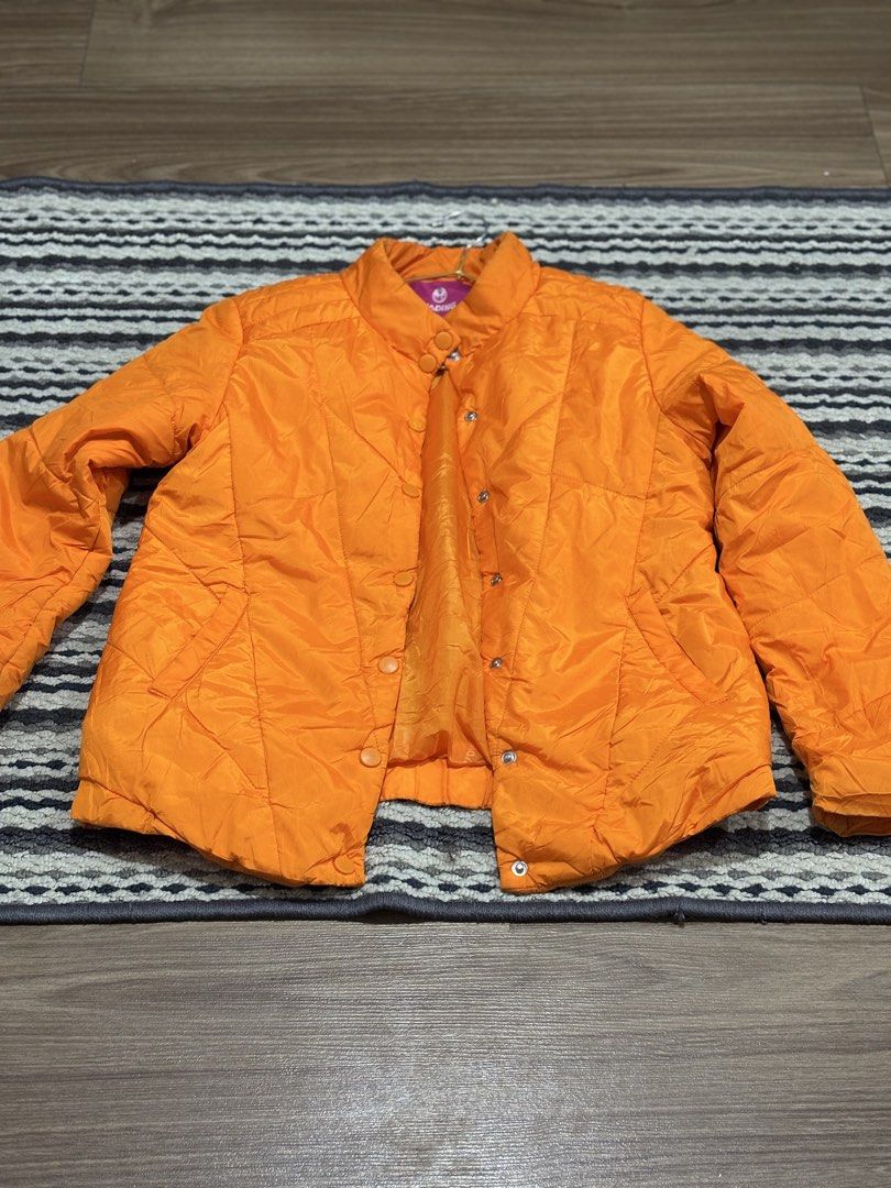 (BRAND NEW) Orange Quilted Puffer Jacket (Category: Coats, Jackets and Outerwear) located in Makati City. Submitted by siopao014 (Listing ID 1464419185, Image 2). Description: - Bright orange quilted puffer jacket - Stand-up collar with button closure - Snap button front - Two side pockets - Ideal for cooler weather - Warm and stylish design.