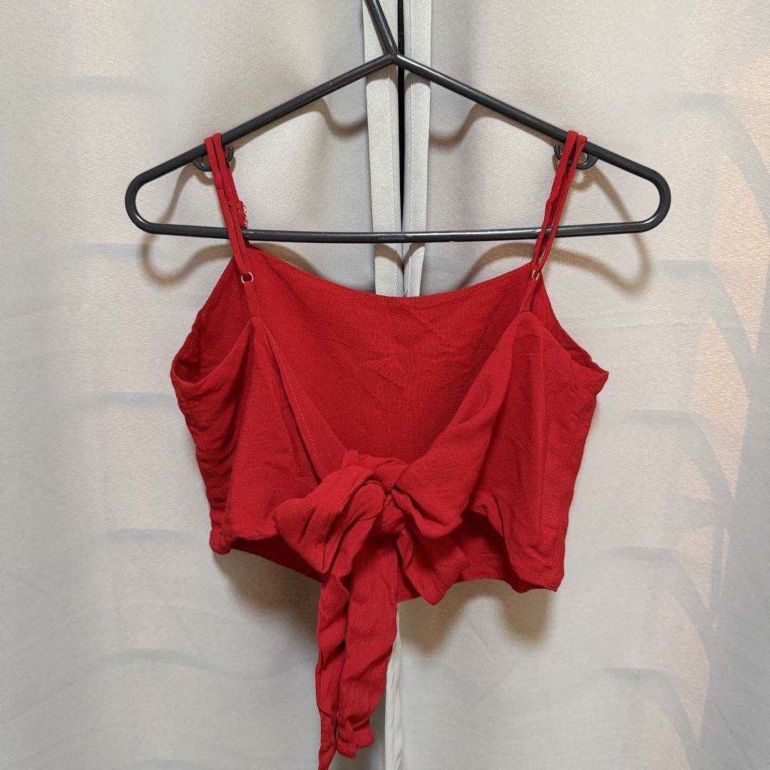 Brandy Melville Red Tie Back Crop Top (Category: Sleeveless) located in Makati City. Submitted by heyitsg_ (Listing ID 1464418405, Image 2). Description: - Cute red crop top from Brandy Melville - Features adjustable spaghetti straps - Tie-back detail for a customizable fit - Textured fabric for added appeal - Versatile for casual wear or dressing up - Easily pairs with jeans or skirts.