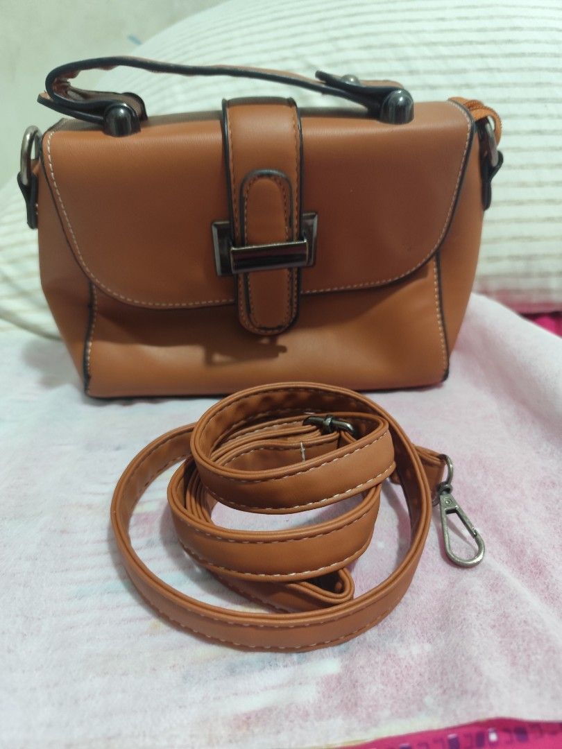 Brown Handbag with Shoulder Strap (Category: Shoulder Bags) located in Manila. Submitted by marriage031073advocate (Listing ID 1464454283, Image 1). Description: - Cute brown handbag - Features a top handle - Includes a detachable and adjustable shoulder strap - Secure metal buckle closure - Detailed stitching around the edges - Ideal for everyday use.