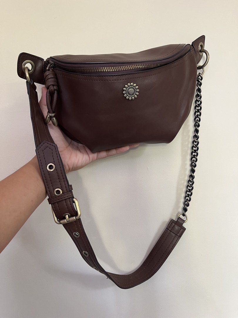 Coffee Brown Leather Bum Bag with Chain Strap (Category: Cross-body Bags) located in Sariaya. Submitted by retro.stuff (Listing ID 1464428114, Image 1). Description: Stylish brown leather bum bag with zip closure. Features card slots inside. Comes with both leather and chain straps for versatile wear as a crossbody or shoulder bag. Minimal scuff but still in pristine condition. .