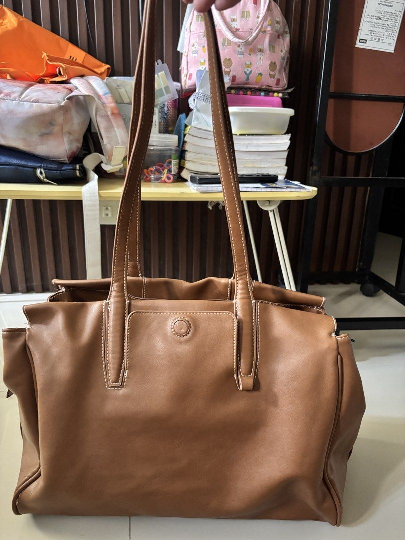 Brown Leather Tote Bag (Category: Tote Bags) located in Manila. Submitted by guivslove04106 (Listing ID 1464392560, Image 1). Description: - Spacious brown tote bag - Made of durable faux leather - Zippered main compartment for security - Internal pockets for easy organization - Comfortable shoulder straps - Ideal for everyday use or travel - Minor marks on leather, as shown in the last photo Location las pinas.