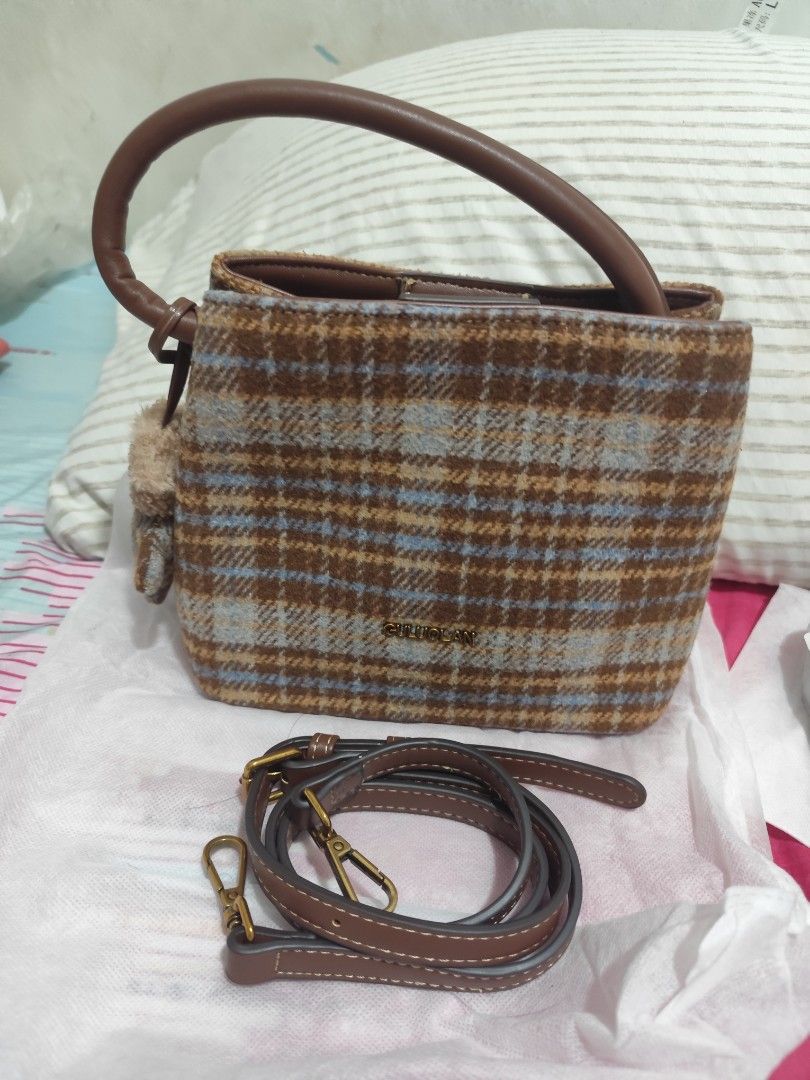 Brown Plaid Handbag with Leather Strap, Tweed Material (Category: Shoulder Bags) located in Manila. Submitted by marriage031073advocate (Listing ID 1464460410, Image 1). Description: - Adorable plaid handbag - Soft and cozy material - Detachable leather strap included - Features a cute fuzzy charm - Ideal for everyday wear and casual outings - Brand name clearly displayed on the front - Used once, No.Issue.