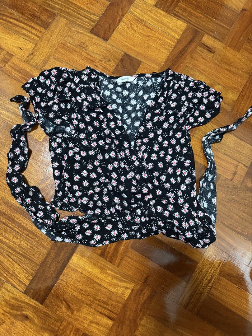Calliope Black Daisy Print Wrap Top Size S (Category: Blouses) located in Paranaque City. Submitted by ferrewr (Listing ID 1464460510, Image 1). Description: - Cute black top with white and red daisy print - Wrap style with side tie details - Short sleeves - V-neckline - Versatile for casual outings or dressing up.