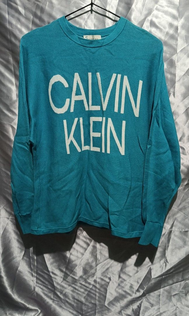 CALVIN KLEIN (Category: Activewear) located in Mandaluyong City. Submitted by newdepot (Listing ID 1464509517, Image 1). Description: Calvin Klein knit long-sleeve sweater featuring a prominent white block logo across the chest Small 20*24 Shoulder to wrist 22.